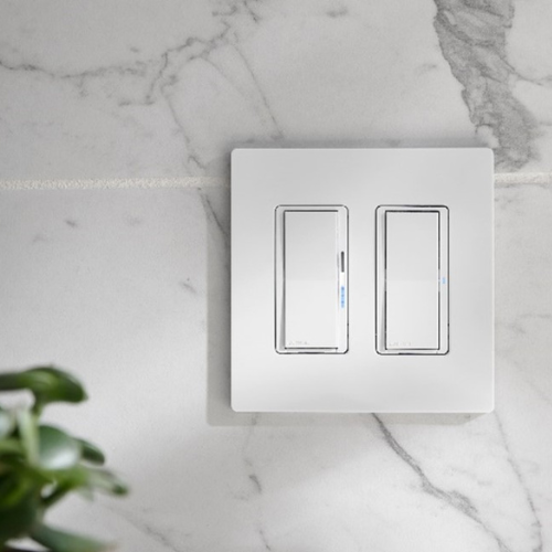 The Lutron Diva Smart Dimmer and Claro Smart Switch installed against a marble backdrop with a plant